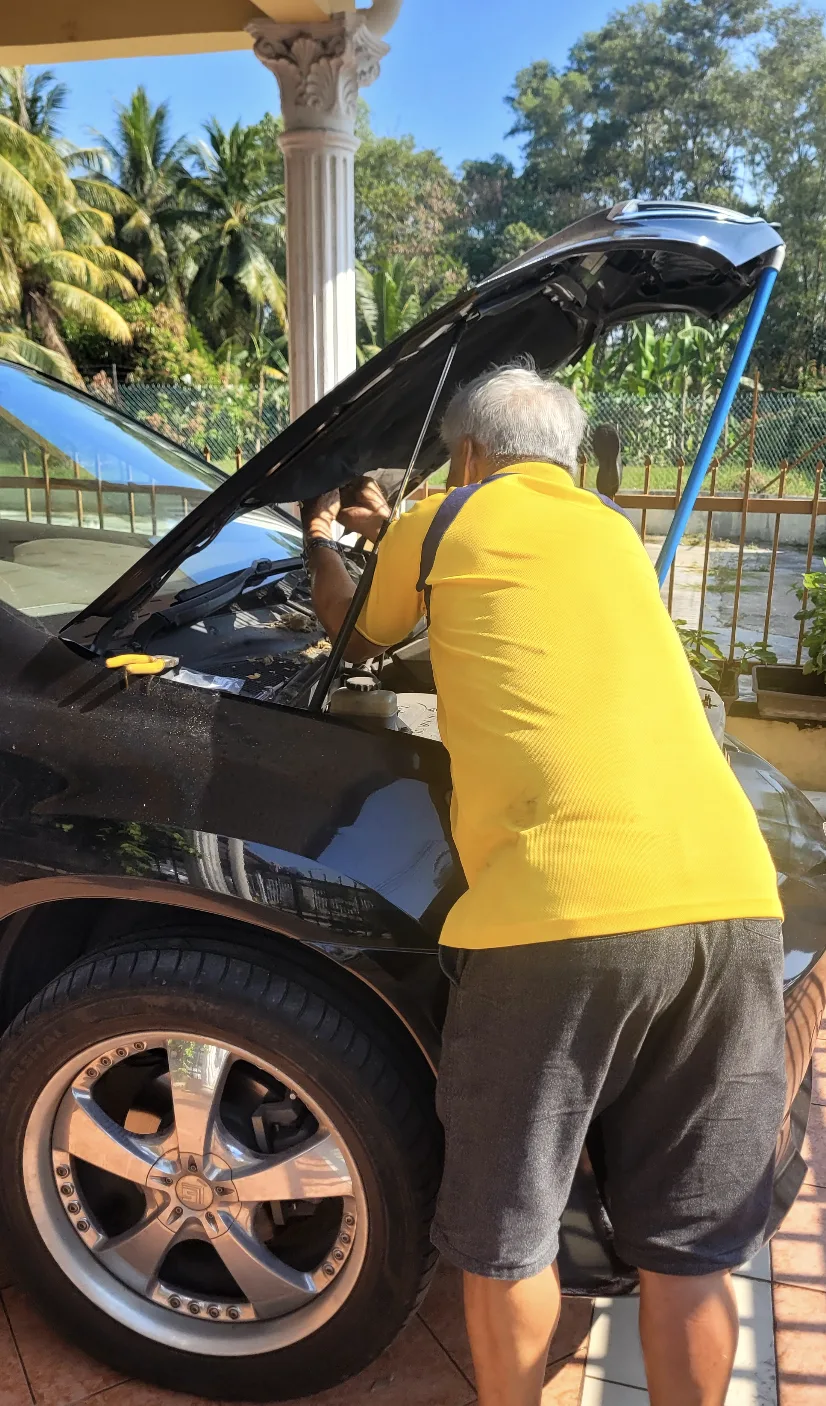 Father-in-law fixing the car under the hood