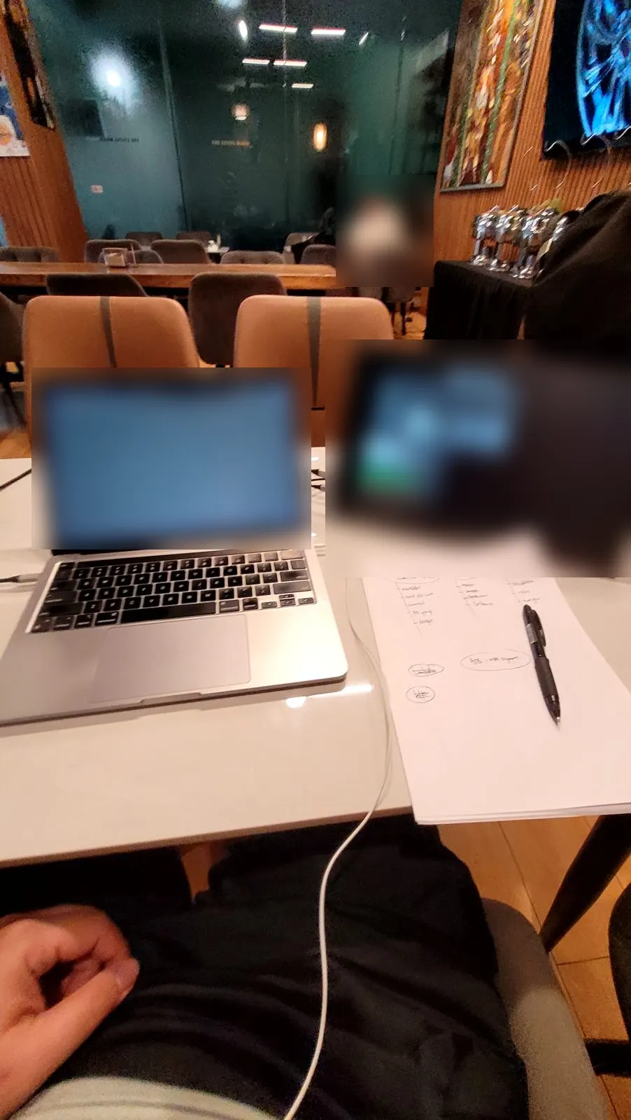 A laptop, a second screen and a hand-drawn plan on a cafe table